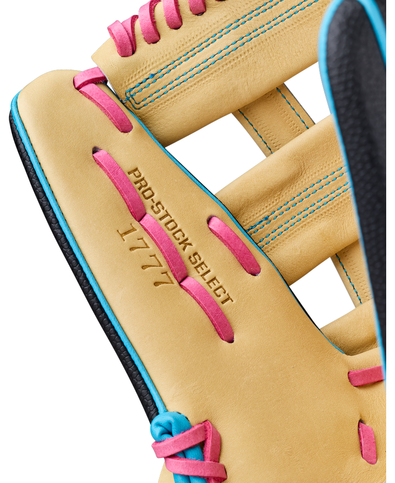 Close-up of a tan Wilson A2K 1777 12.75″ Baseball Glove (WBG0010301) featuring pink laces and blue stitching. The glove is stamped with “PRO-STOCK SELECT” and “1777,” highlighting its Double Palm Construction for enhanced durability.
