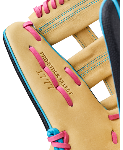 Close-up of a tan Wilson A2K 1777 12.75″ Baseball Glove (WBG0010301) featuring pink laces and blue stitching. The glove is stamped with “PRO-STOCK SELECT” and “1777,” highlighting its Double Palm Construction for enhanced durability.