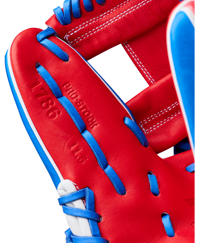 Close-up of the Wilson A2000 1786SS 11.5" Baseball Glove (GOTM July 2026) showing red Pro Stock leather with blue and white laces, embossed text, and detailed stitching—model WBG0018202RT1786.