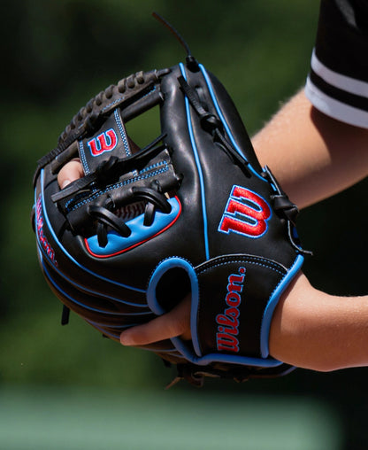 A player wearing a black Wilson A1000 DP15 11.5″ Baseball Glove: WBG02402RTDP15 with blue piping and red embroidered logos.