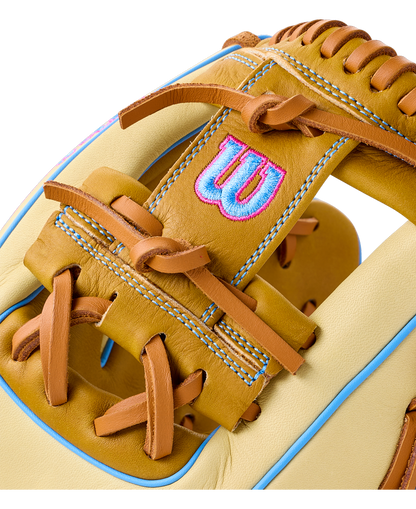 Close-up of a Wilson A1000 1786 11.5″ Baseball Glove: WBG02501RT1786 in tan and cream with light blue accents and an embroidered blue and pink logo on the wrist strap.