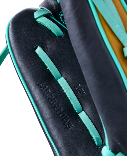 Close-up of a black Wilson A1000 DW5 12″ Baseball Glove: WBG02701RTDW5 with teal lacing and gold-colored accents.