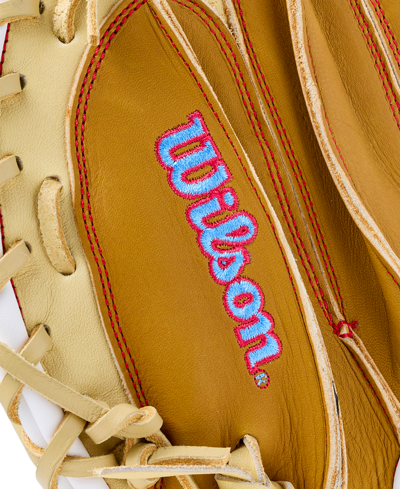 Close-up of a tan Wilson A1000 PF33 33″ Baseball Catcher’s Mitt: WBG03001RTPF33 with a light blue and pink embroidered logo.
