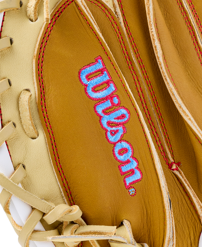 Close-up of a tan Wilson A1000 PF33 33″ Baseball Catcher’s Mitt: WBG03001RTPF33 with a light blue and pink embroidered logo.