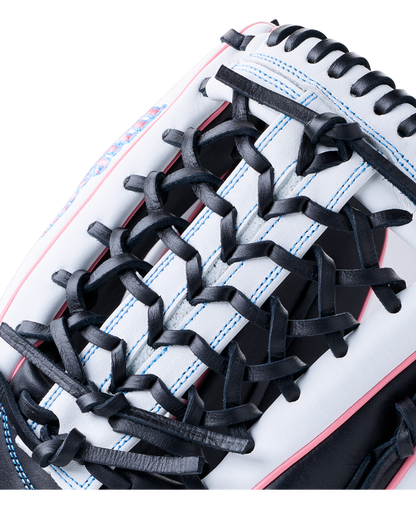 Close-up of a white and black Wilson A1000 T125 12.5″ Fastpitch Glove: WBG03501RTT125 with blue stitching and pink piping.