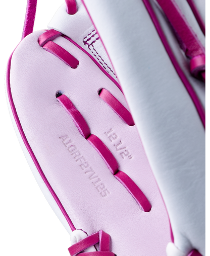 Close-up of a white and pink Wilson A1000 V125 12.5″ Fastpitch Glove, showing the 12 1/2 inch size and model number embossed on the palm.
