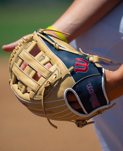 A tan and navy full grain leather Wilson A900 12″ Baseball Glove: WBG04101RT12 worn on a player’s hand, designed with a Pedroia Fit.