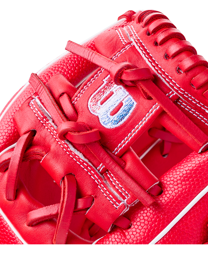 Close-up of a bright red Wilson A1000 PF11SS 11″ Baseball Glove featuring a stitched logo on the wrist strap and intricate lacing detail.