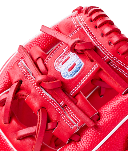 Close-up of a bright red Wilson A1000 PF11SS 11″ Baseball Glove featuring a stitched logo on the wrist strap and intricate lacing detail.