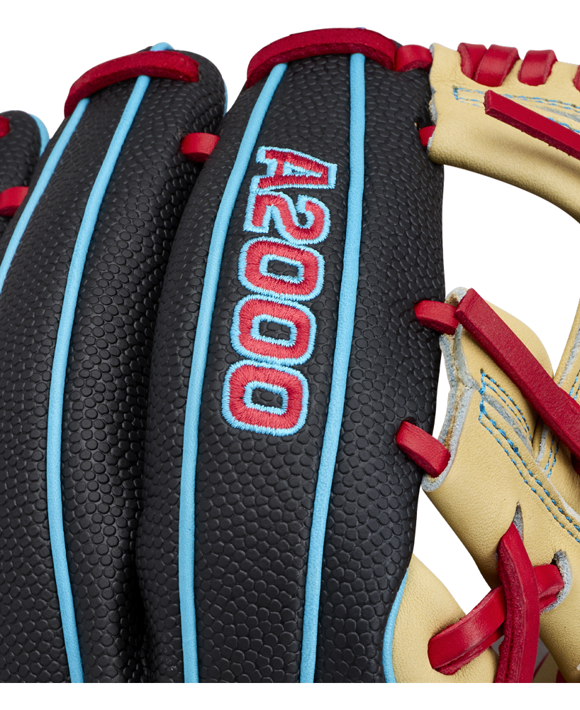 Close-up of the Wilson A2000 DP15SS 11.5″ Baseball Glove (WBG05501RT115) displaying blue piping, red stitching, and “A2000” embroidered in blue and red on the leather surface. This glove features the renowned Pedroia Fit by Wilson, engineered for superior comfort and performance.
