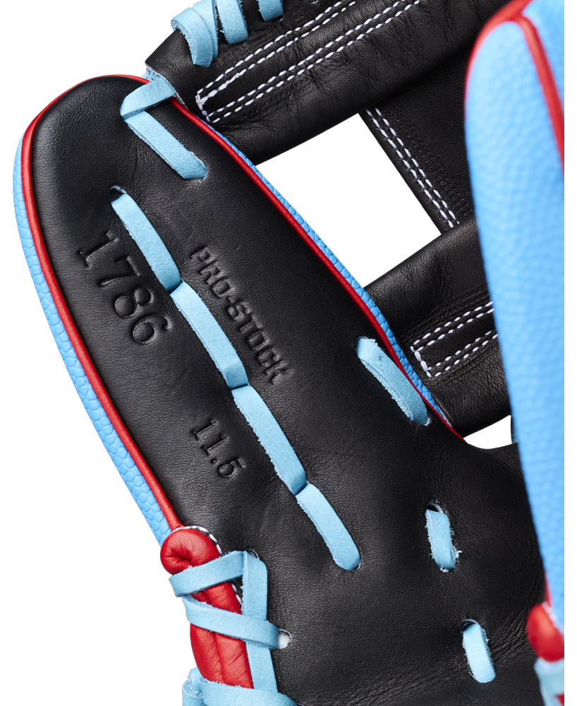 A close-up view of the Wilson A2000 1786SS 11.5″ Baseball Glove (WBG05601RT115) by Wilson, featuring a black design with blue laces and red trim, and displaying the embossed text “1786,” “PRO-STOCK,” and “11.5” baseball glove” on the palm area.