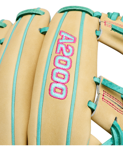 Close-up of a tan Wilson A2000 1975 11.75″ Baseball Glove (WBG05701RT1175) featuring teal laces, pink stitching, and an extra deep pocket. Bold pink and teal “A2000” embroidery adds a striking touch to this premium infield glove from Wilson.