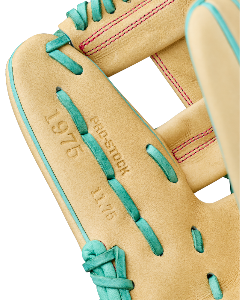 Close-up of a tan Wilson A2000 1975 11.75″ Baseball Glove (WBG05701RT1175) with teal lacing, highlighting the embossed text “1975,” “PRO-STOCK,” and “11.75” on the inside. This Wilson glove features an extra deep pocket, while pink stitching is visible on the webbing.