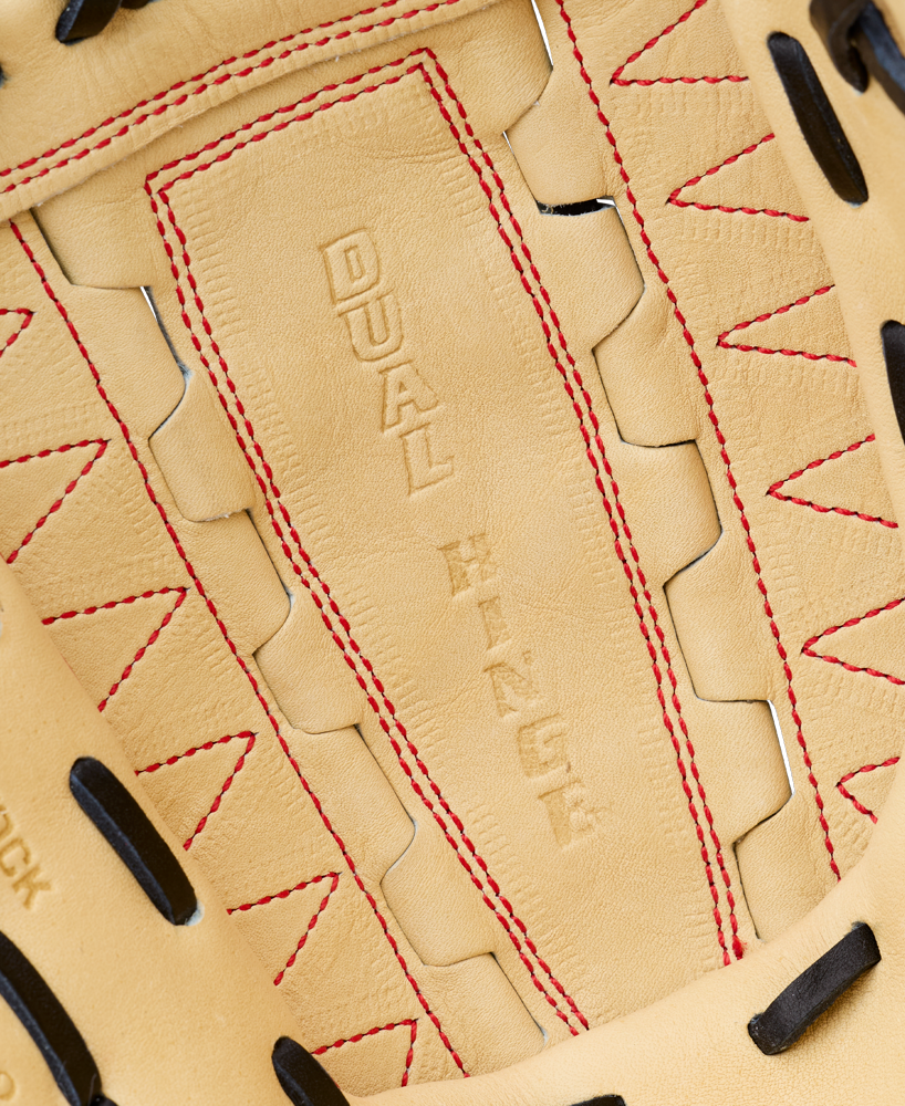 Close-up of a tan Wilson A2000 DH12 12″ Baseball Glove (WBG06101RT12) made from Pro Stock leather, featuring red stitching, black laces, and the embossed words DUAL HINGE visible on the palm. This Wilson pitcher’s glove showcases a classic Dual Hinge Web design.