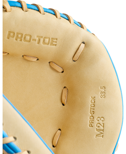 Here’s a revised version of the sentence using your product data: Close-up of the Wilson A2000 M23SS 33.5″ Baseball Catcher’s Mitt, featuring blue laces and tan leather embossed with PRO-TOE and PRO-STOCK M23 33.5—expertly crafted by Wilson for catcher’s mitt precision and outstanding pitch-framing skills.