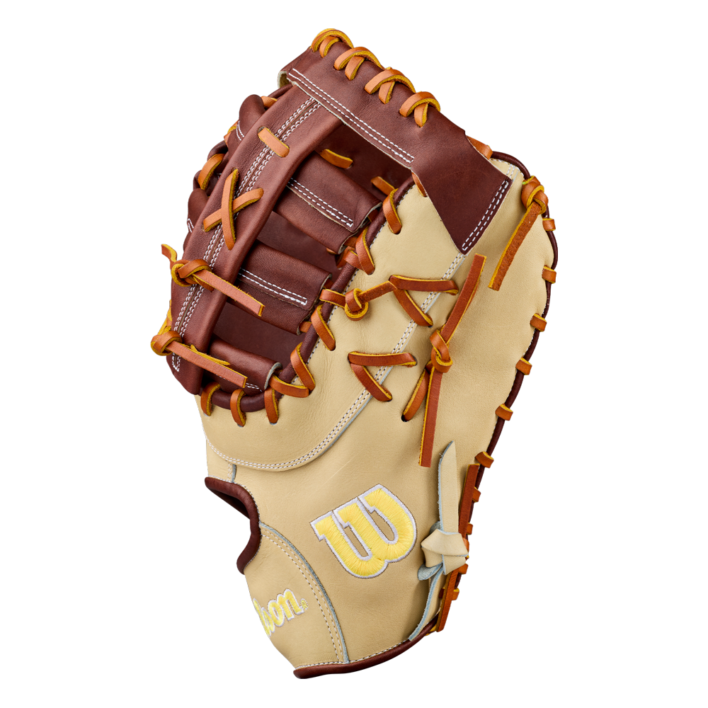 A light tan and brown Wilson A2000 1673 13″ Baseball First Base Mitt (WBG06401RT13) with orange laces, featuring detailed stitching and the embroidered Wilson “W” logo on the side. Crafted from Pro Stock leather, this spacious 13-inch glove is open to reveal its generous pocket and webbing—ideal for play at first base.