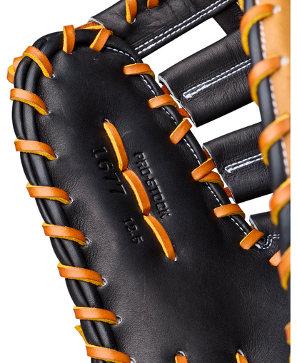 Close-up of a Wilson A2000 1677 12.5″ Baseball First Base Mitt (WBG06501RT125) in black Pro Stock leather, highlighted by orange laces, white stitching, and the embossed text “PRO SELECT 1677 12.5” on the palm area.