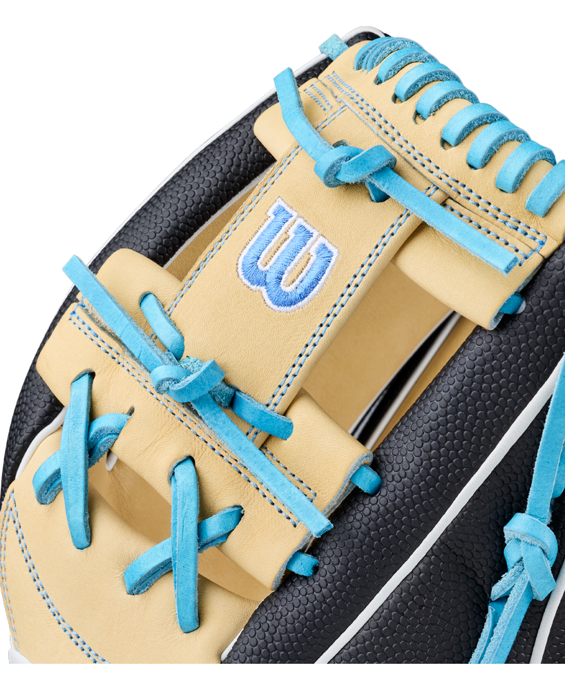 Close-up of the Wilson A2000 FP1175SS 11.75″ Fastpitch Glove (WBG06601RT1175) by Wilson, featuring beige and black leather, blue stitching, and blue laces. The iconic W is embroidered in blue and white on the beige leather section, showcasing this premium infield softball glove’s meticulous attention to detail.