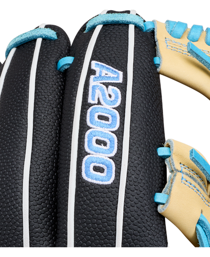 Close-up of the Wilson A2000 FP1175SS 11.75″ Fastpitch Glove, featuring black leather with white edging, blue stitching, and the model name “A2000 FP1175SS” embroidered in blue and white letters. The glove also displays part of its tan leather webbing.