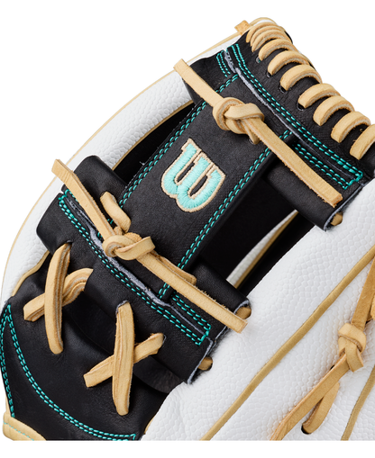 Close-up of a white, black, and tan Wilson A2000 H12SS 12″ Fastpitch Glove (WBG06701RT12) with teal stitching and the signature W logo embroidered on a black leather section. The glove’s laces and textured leather are clearly visible, emphasizing its premium fastpitch design from Wilson.