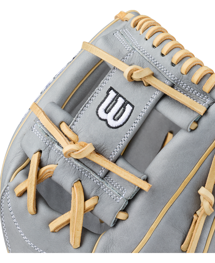 Close-up of a gray Wilson A2000 H12 12″ Fastpitch Glove: WBG06801RT12 with tan laces and white stitching, featuring a black and white embroidered Wilson “W” logo on the wrist strap. This 12” infield glove delivers premium performance and durability for serious players.
