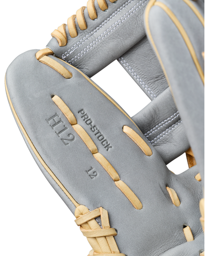 Close-up of a gray leather Wilson A2000 H12 12″ Fastpitch Glove (WBG06801RT12) with tan laces. Text on the glove reads H12, PRO STOCK, and 12” infield glove.