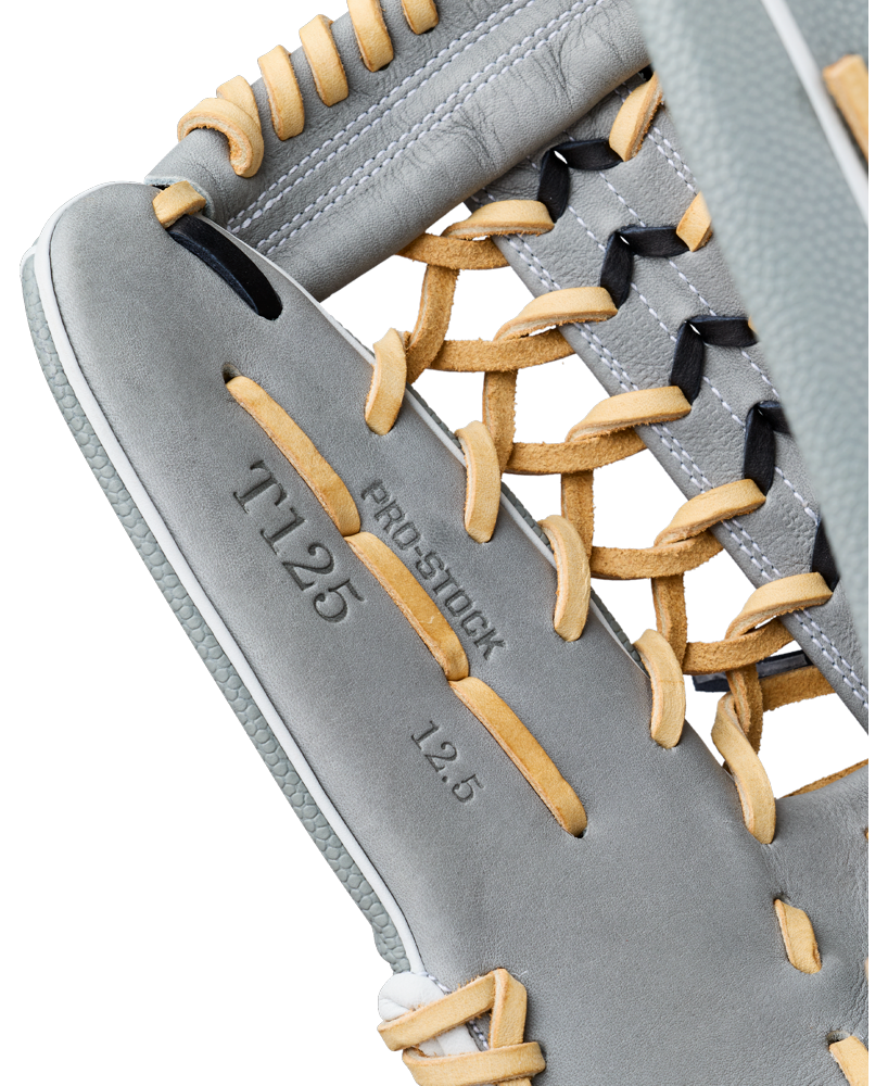 Close-up of a grey Wilson A2000 T125SS 12.5″ Fastpitch Glove with tan laces, featuring the embossed text PRO STOCK, T125, and 12.5 near the webbing—ideal as a 12.5″ outfield glove for fastpitch play.