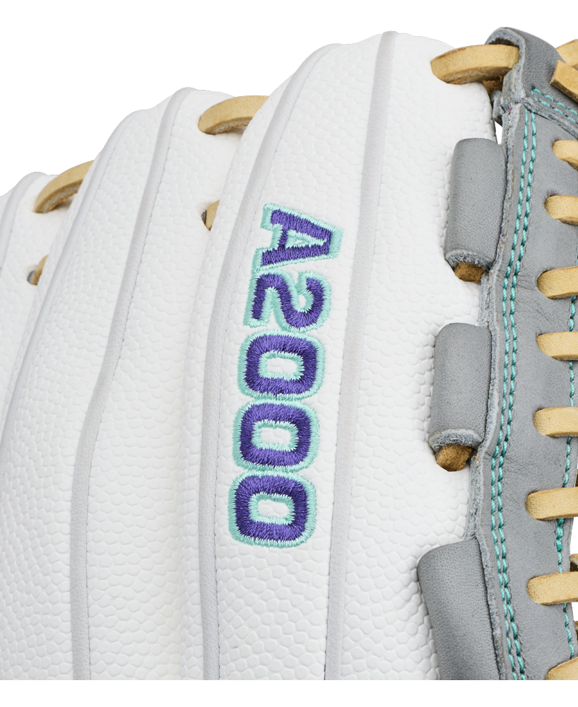 Close-up of a white Wilson A2000 FPHGSS 12″ Fastpitch Glove (WBG07101RT12) with “A2000” embroidered in blue and teal thread. Tan laces and gray leather accents appear on the right side of the glove, which is designed with Wilson’s Flex System for added comfort—making it an ideal choice for softball infielders.