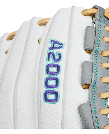 Close-up of a white Wilson A2000 FPHGSS 12″ Fastpitch Glove (WBG07101RT12) with “A2000” embroidered in blue and teal thread. Tan laces and gray leather accents appear on the right side of the glove, which is designed with Wilson’s Flex System for added comfort—making it an ideal choice for softball infielders.