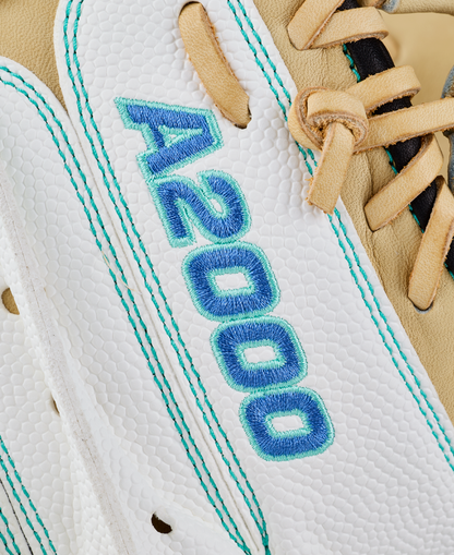 Close-up of the Wilson A2000 FPCM23SS 34″ Fastpitch Catcher’s Mitt (WBG07301RT34) in white and tan leather, with “A2000” stitched in blue and teal thread on the white section, featuring a Dual Post Web design for enhanced stability and control.