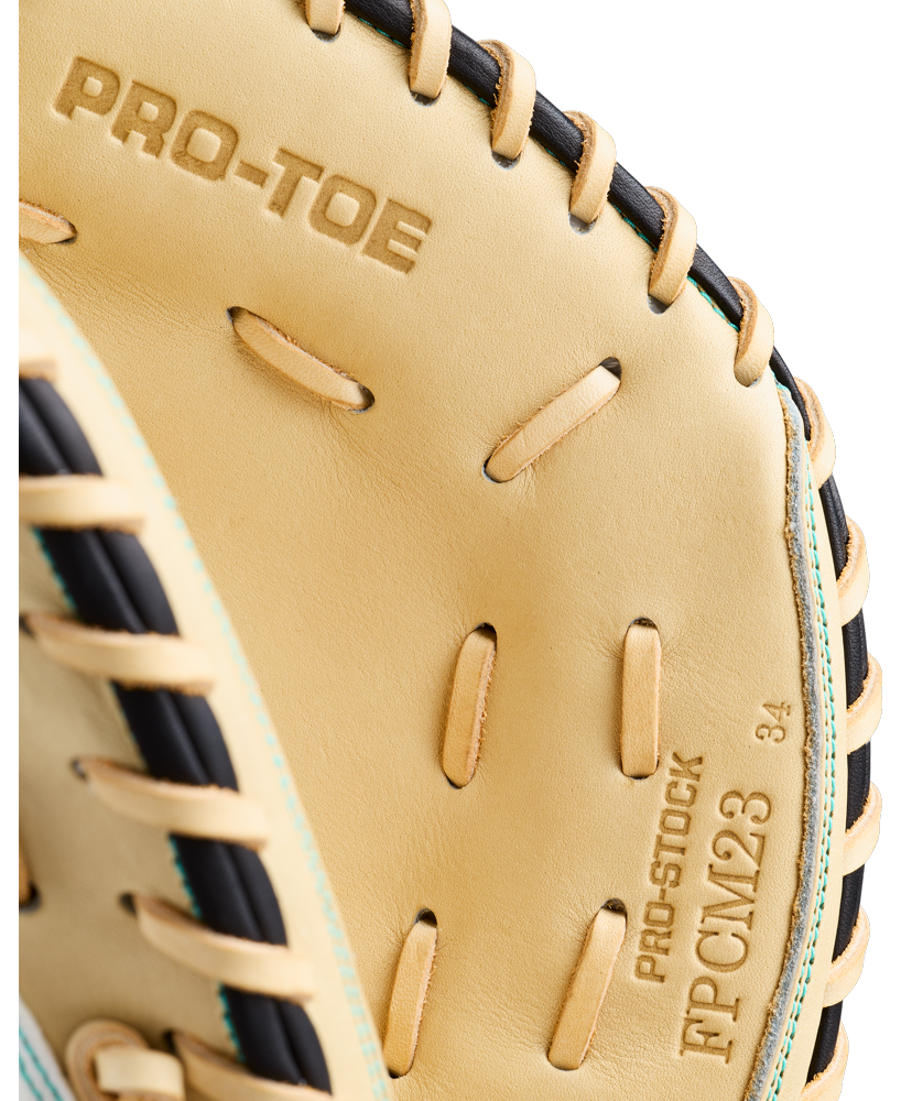 Close-up of a Wilson A2000 FPCM23SS 34″ Fastpitch Catcher’s Mitt featuring tan leather with black laces. This Wilson glove showcases a Dual Post Web design and has PRO-TOE, PRO-STOCK, FPCM23, and the number 34 stamped on it.