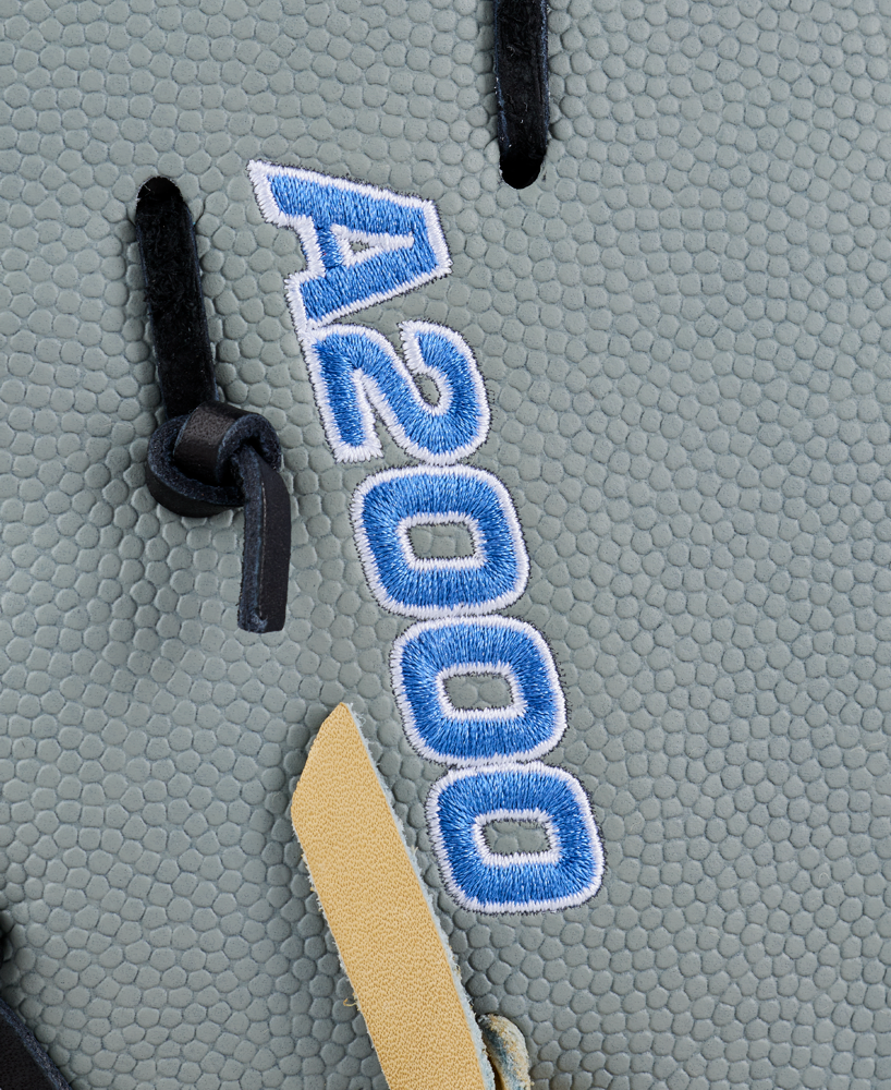 Close-up of the Wilson A2000 FP1620SS 12.5″ Fastpitch First Base Mitt, crafted from textured gray Pro Stock leather with black laces, blue and white A2000 embroidery, and a small tan leather accent—expertly designed by Wilson for fastpitch first basemen.