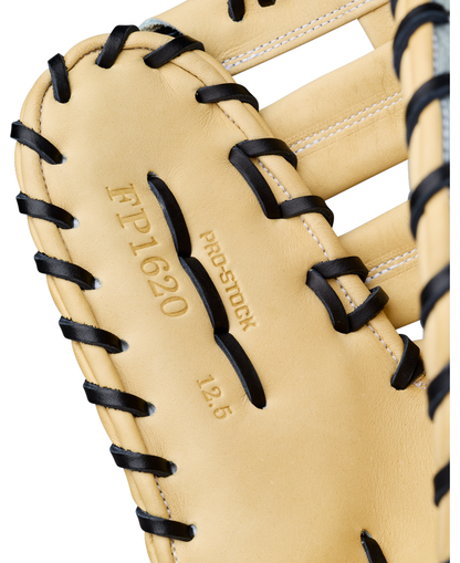 Here’s a revised version of your sentence, incorporating the provided product data: Close-up of a tan 12.5” Wilson A2000 FP1620SS Fastpitch First Base Mitt, expertly crafted from Pro Stock leather with contrasting black laces. The glove displays the markings “FP1620,” “PRO STOCK,” and “12.5” to signify its model and size, with white stitching accentuating the leather sections throughout this Wilson mitt.
