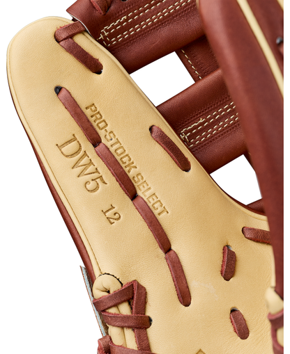 Close-up of a tan and brown Wilson A2K DW5 12″ Baseball Glove (WBG07801RT12) by Wilson, featuring PRO STOCK SELECT, DW5, and 12 embossed on the leather inside the thumb area, and showcasing intricate stitching details crafted from premium Pro Stock Select leather.