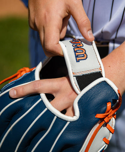 Hands adjusting the quick fit wrist strap of a blue and white Wilson A500 10.5″ Baseball Glove: WBG08401RT105 with orange laces.