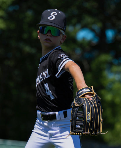 A baseball player wearing a black uniform and mirrored sunglasses holds a black leather Wilson A500 12.5″ Baseball Glove: WBG08801RT125.