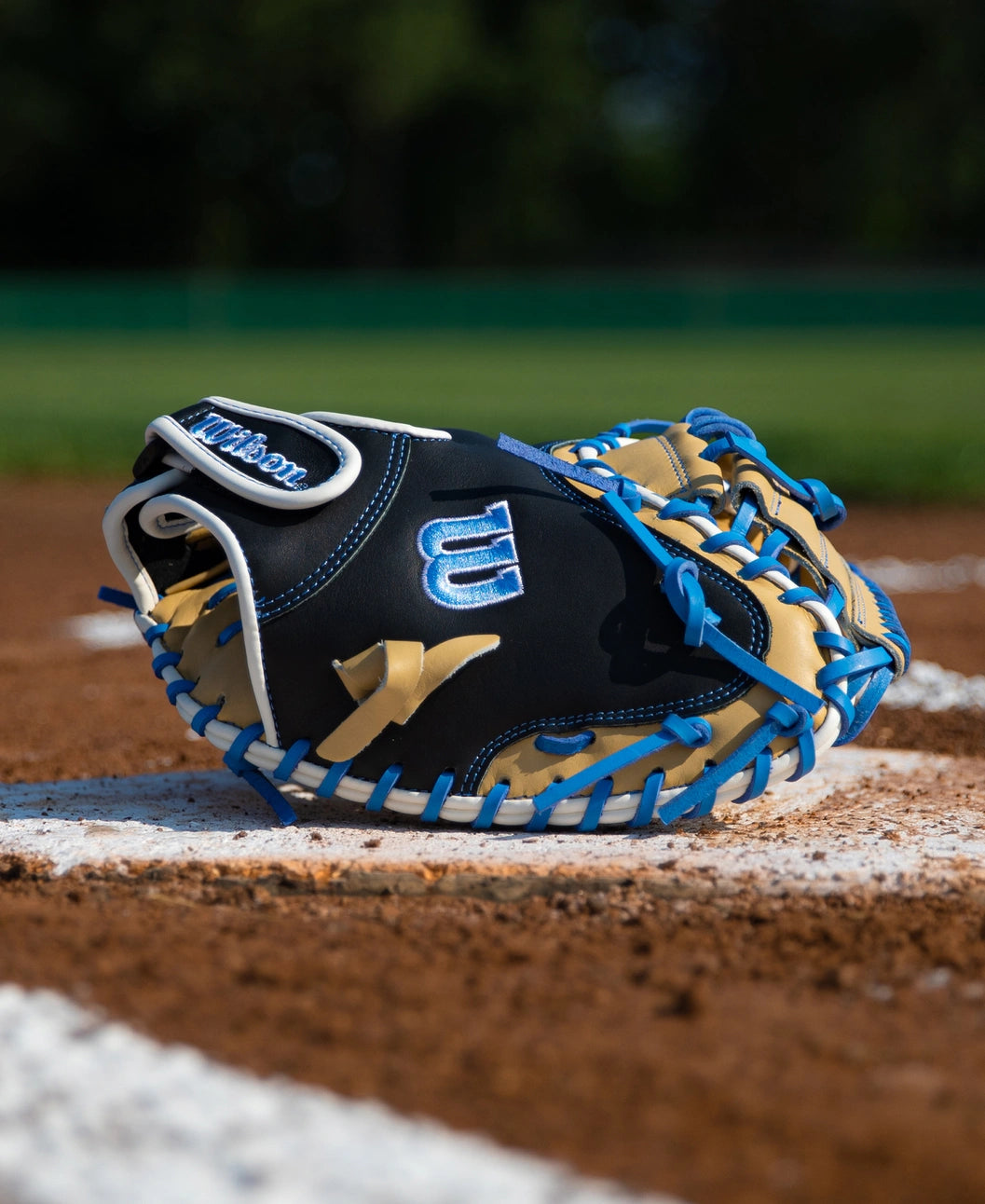 Wilson A500 32″ Baseball Catcher’s Mitt: WBG08901RT32 in black, tan, and blue with a quick fit wrist resting on a baseball field.