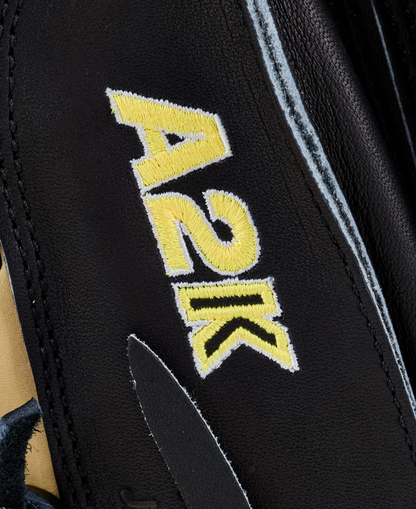 Close-up of black leather on the Wilson A2K 1734 34″ Baseball Catcher’s Mitt (WBG10701RT34) by Wilson, showcasing yellow and white embroidered A2K text, visible stitching, rich leather texture, and detailed Double Palm Construction.