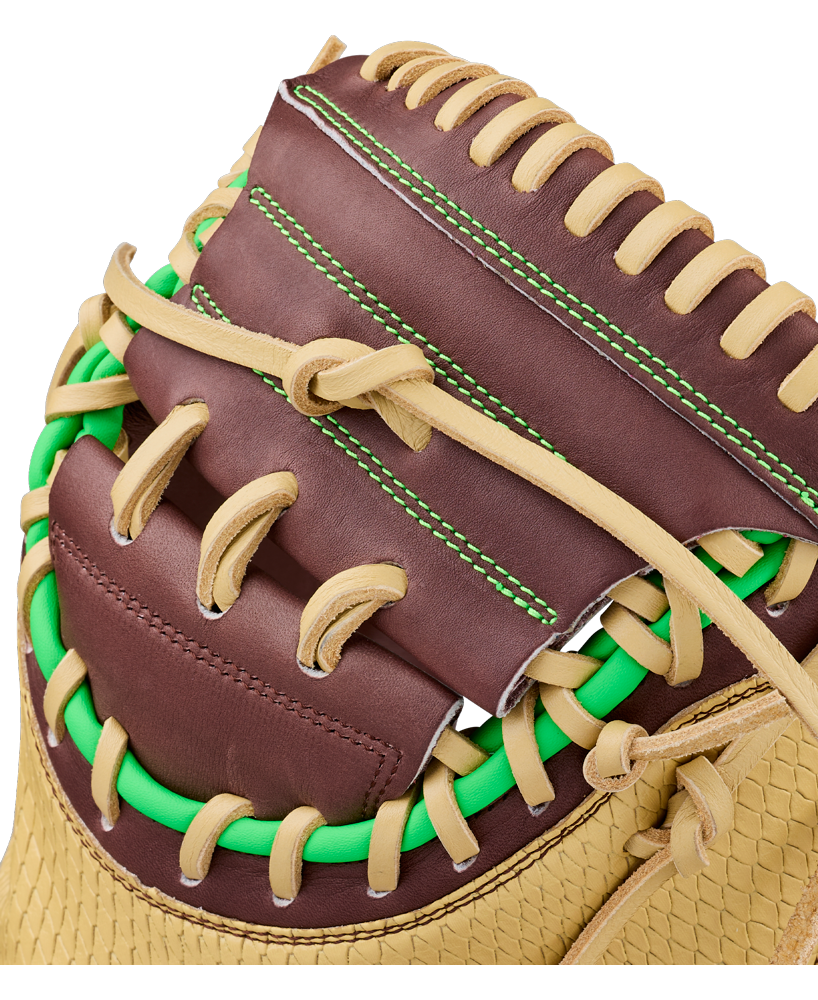 Close-up of a Wilson A1000 CM33 DUBAI 33″ Baseball Catcher’s Mitt (WBG25101RT33) by Wilson, featuring brown and tan leather, green stitching, and bright green lacing around the webbing, highlighting the intricate details of the glove’s construction.