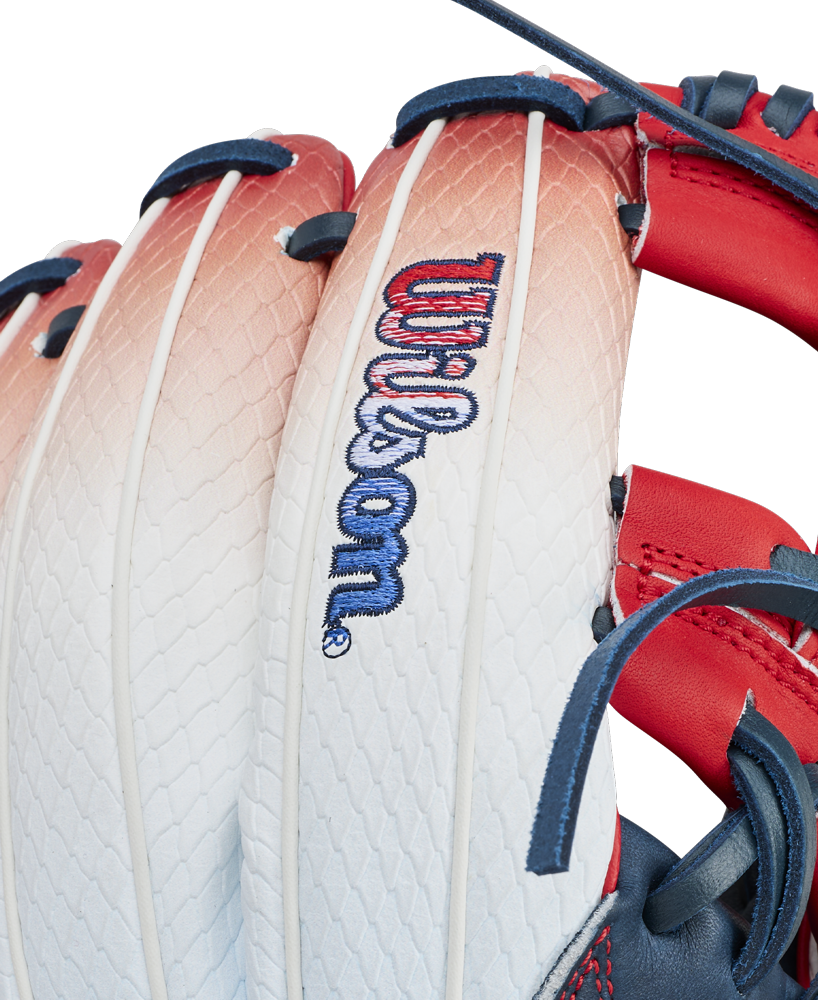 Close-up of the Wilson A1000 1787 FREEBIRD 2.0 11.75″ Baseball Glove (WBG26501RT1175) by Wilson, showcasing its white and red Full Grain leather construction with blue laces and visible stitching. The glove features an embroidered Wilson logo on the back.