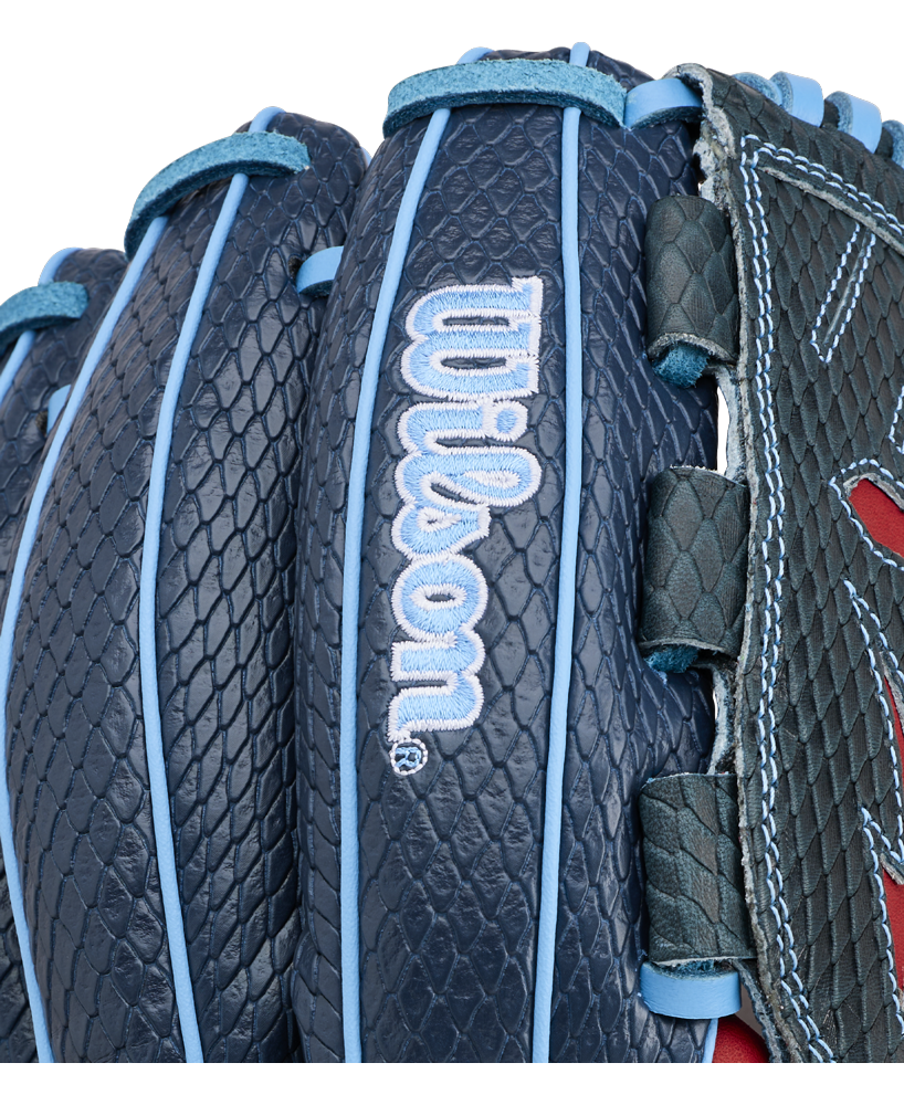 Close-up of a Wilson A1000 B23 GENO 12″ Baseball Glove (WBG26601RT12) by Wilson, featuring a dark blue color with a textured, scale-like pattern and light blue stitching and laces.