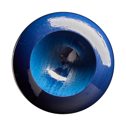 A round, deep blue ceramic bowl viewed from above, with glossy, reflective patches and textured gradient shades of blue inside—its rich color reminiscent of the vibrant hues found on a Louisville Slugger Youth Prime Savannah Bananas RA13 Maple Wood Baseball Bat (WBL4160010) by Louisville Slugger.