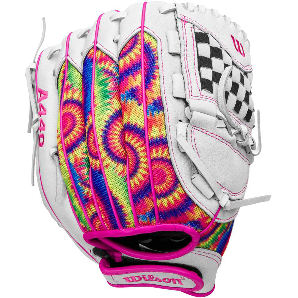 The Wilson Flash 11.5" Fastpitch Glove (WBW101640115) features a tie-dye design in pink, yellow, blue, and green with white leather accents, pink stitching, a black-and-white checkerboard web, and the Wilson logo.
