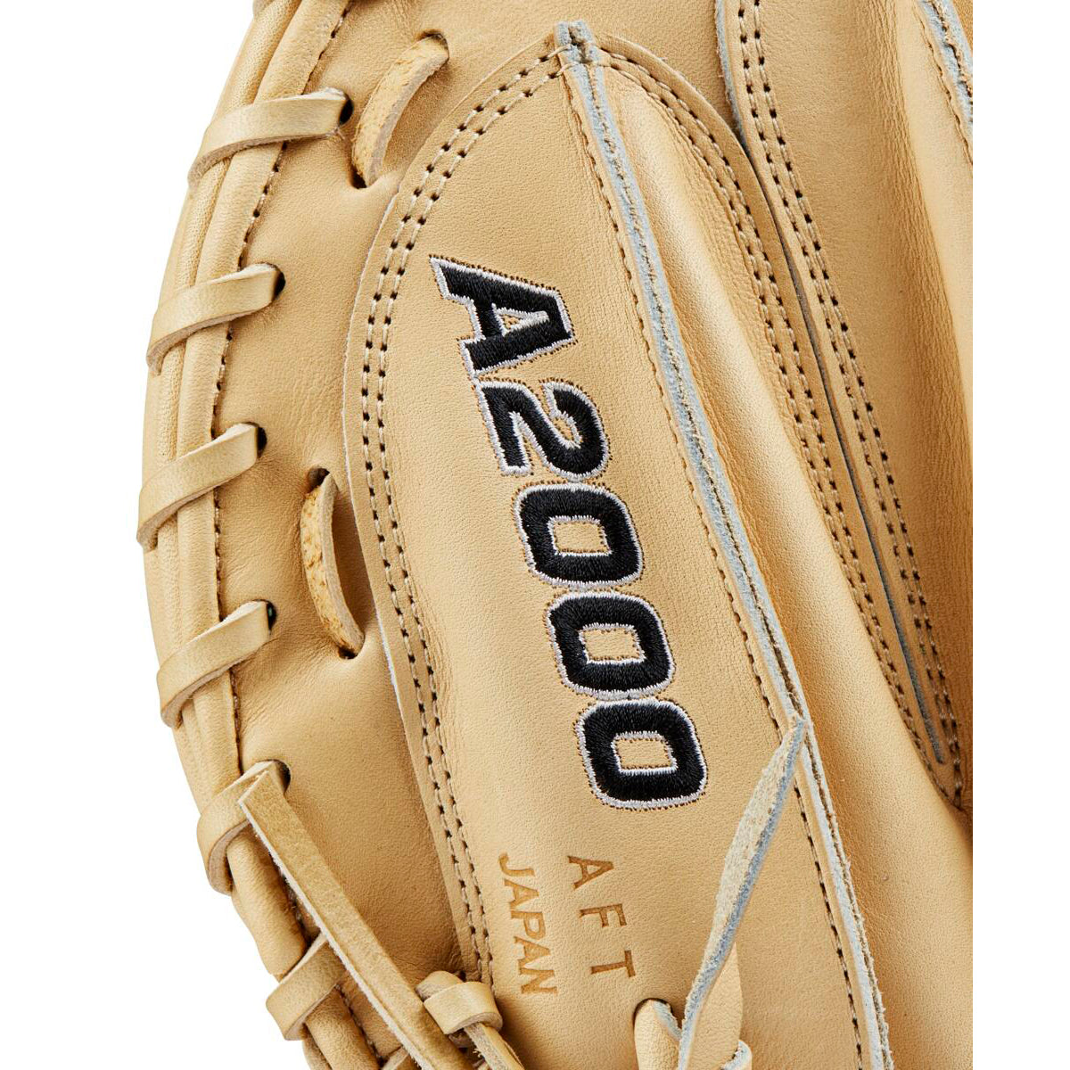 Close-up of a tan Wilson A2000 M23 33.5" Baseball Catcher's Mitt (WBW102093335) with black embroidered A2000 lettering and “A F T JAPAN” stamp, showcasing the Pro Stock leather texture and detailed stitching.