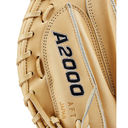Close-up of a tan Wilson A2000 M23 33.5" Baseball Catcher's Mitt (WBW102093335) with black embroidered A2000 lettering and “A F T JAPAN” stamp, showcasing the Pro Stock leather texture and detailed stitching.