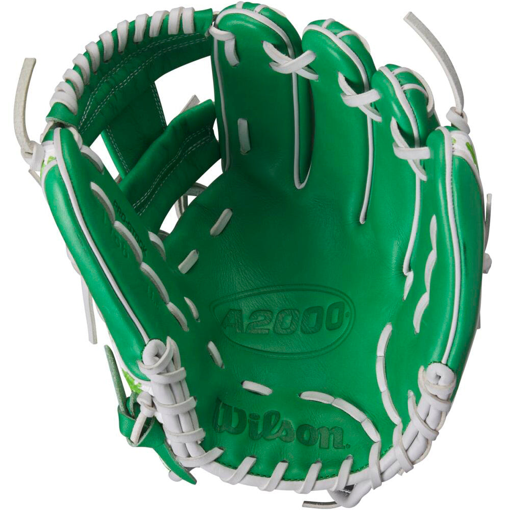 A Wilson A2000 1786 11.5" MDA Shamrocks baseball glove by Wilson is shown open, featuring green leather with white lacing and the brand name and model visible inside the palm.