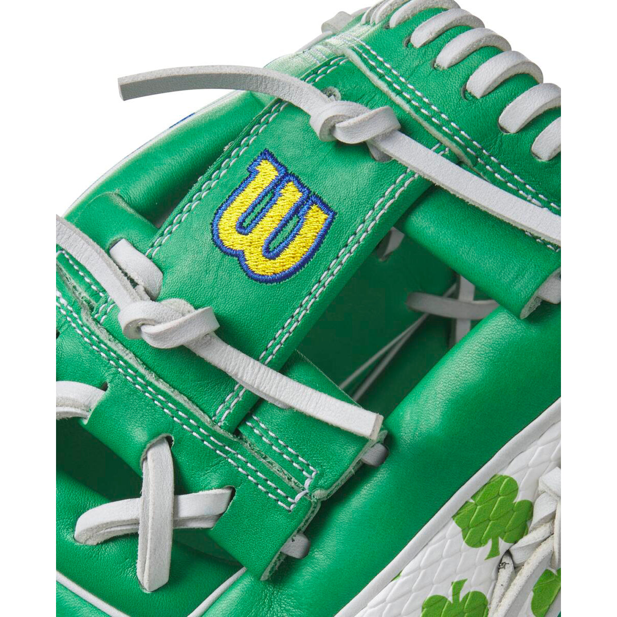 Close-up of a Wilson A2000 1786 11.5" MDA Shamrocks Baseball Glove (WBW102148115) featuring green Pro Stock leather, white laces and stitching, a yellow and blue W logo, and green shamrocks on a stylish white section.