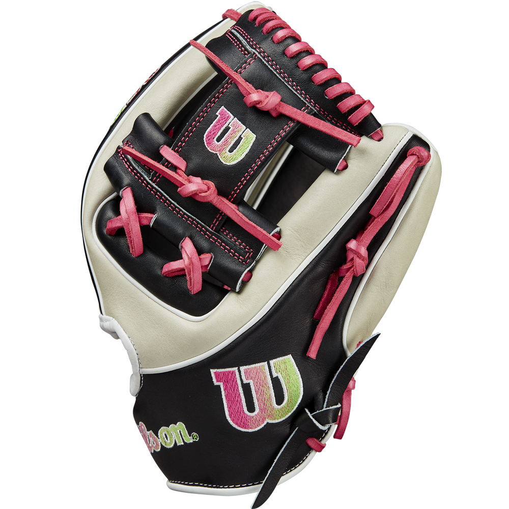 The Wilson A2K 1724 11.75" Baseball Glove GOTM June 2024 (WBW1022571175) features black, white, and pink Pro Stock Select leather, red laces, and green and pink “W” logos on the wrist and web; shown upright on a white background.