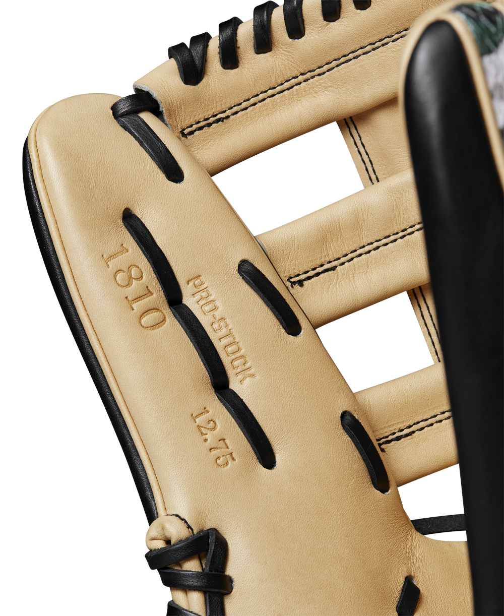Close-up of a tan Wilson A2000 1810 12.75" Baseball Glove (WBW1025271275) with black laces, featuring embossed text "1810," "PRO STOCK leather," and "12.75" on the leather interior.