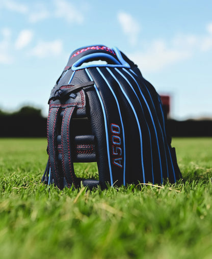 A Wilson A500 12" Baseball Glove (WBW10254212) from Wilson rests on the grass, perfect for young athletes looking to improve their game.